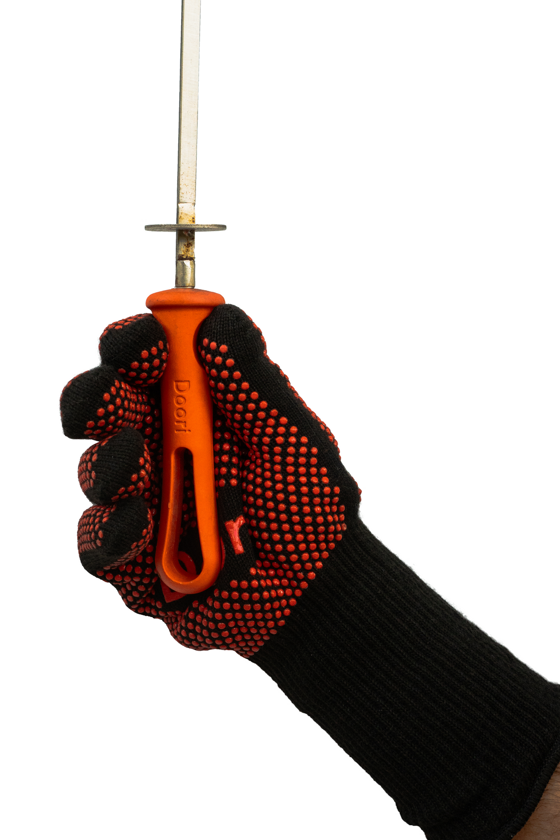 A hand wearing the Doori Cooking Gloves holding a skewer.