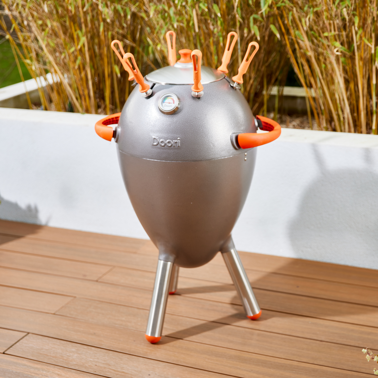 The Doori Outdoor Cooker on a deck with bamboo in the background.